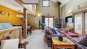 Ein gemütliches Wohnzimmer mit Kamin, einer Treppe und einem Schild mit der Aufschrift 'SUPERSTAR'.