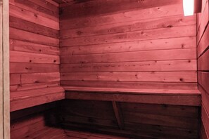 A wooden cabin interior with a sloped ceiling and a visible wooden beam structure.