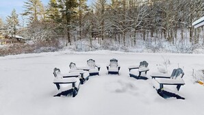 Lumipeitteinen ulkoalue, jossa on Adirondack-tyylisiä tuoleja aseteltuna puolipiiriin.