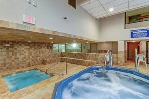 An indoor swimming pool with a tiled wall, an exit sign, and a sign for Mountain Green Health Spa. - Top-Floor Condo w/ view of Killington ski slopes, shared pool, hot tub, sauna (Killington)