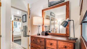 Ein hölzerner Kommode mit Spiegel, Lampe und kleinem Radio.