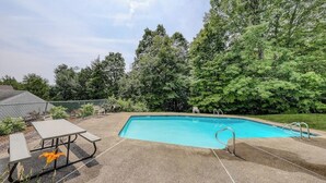 A rectangular swimming pool with a concrete deck, surrounded by trees and a fence. - Ski-In/Ski-Out Second-Floor Condo w/ Free WiFi, Mountain Views, & a Shared Pool (Warren)