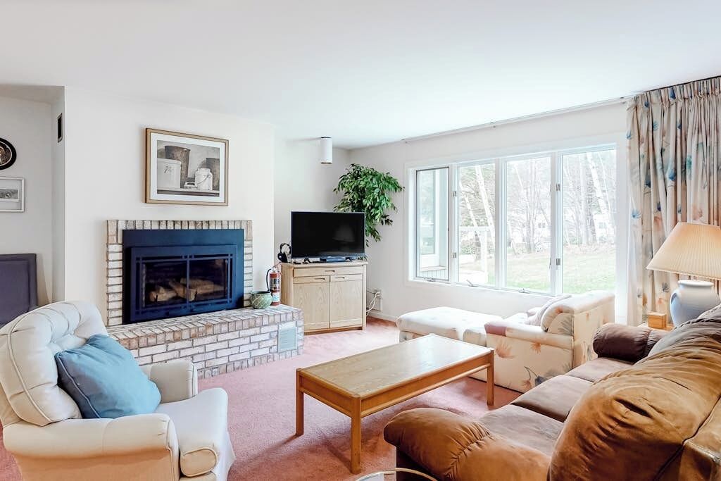 A living room with a fireplace, television, and comfortable seating.