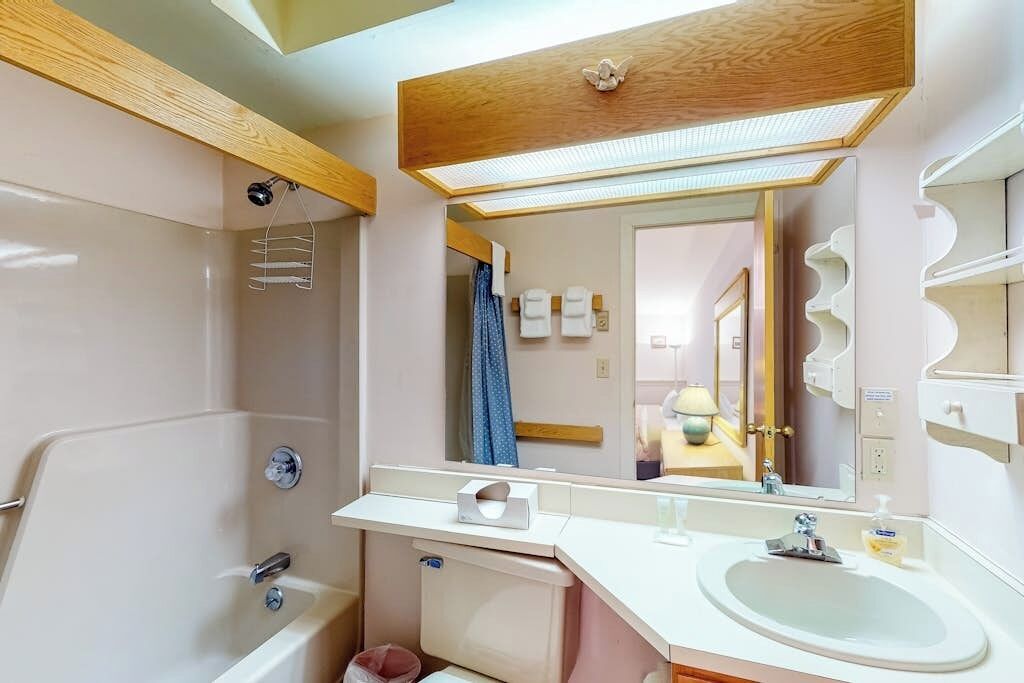 A modern bathroom with a shower, a sink, and a mirror.