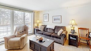 Un salon comprenant un canapé, un fauteuil, une table basse et deux lampes.