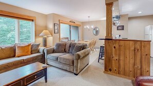 A living room with a sofa, coffee table, and a wooden bar area.