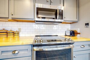 Eine Küche mit Edelstahlbackofen, Mikrowelle und Toaster.