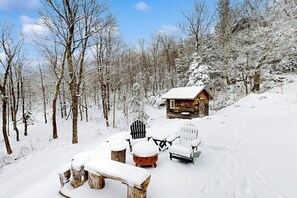 A cabin with a snow-covered roof, surrounded by a snowy forest. - Quintessential wilderness retreat with mtn views & kayaks - dog-friendly (Warren)