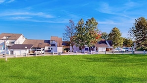 A residential area with houses, a grassy field, and a clear blue sky. - Convenient Skier-friendly 1BR condo, pool, gym, tennis, fireplace, wifi (Warren)