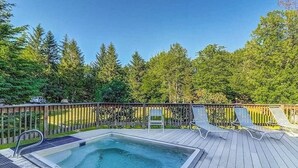 A swimming pool with a wooden deck, lounge chairs, and a wooden fence. - Convenient Skier-friendly 1BR condo, pool, gym, tennis, fireplace, wifi (Warren)