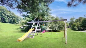 Ein Spielplatz mit Rutsche und Schaukeln.