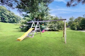 Ein Spielplatz mit Rutsche und Schaukeln.