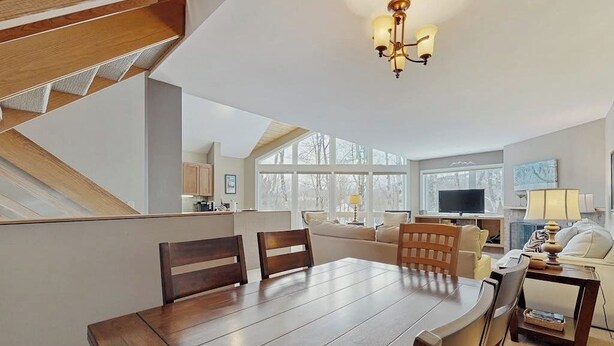 A modern kitchen with a dining area, large windows, and a staircase. - Convenient townhouse w/ seasonal mountain views, pool, tennis, w/d, a/c, wifi (Warren)