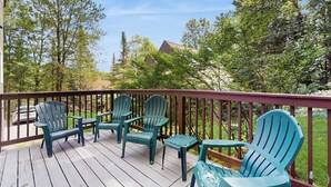 A wooden deck with green Adirondack chairs and a small table. - Home w/ mountain view, deck, shared pool & tennis, w/d (Warren)
