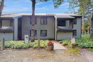 A two-story building with a flat roof, a visible entrance, and a sign indicating no parking.