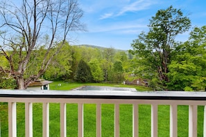 A fenced yard with a small shed, trees, and a hilly landscape in the background. - Four Season Condo:  seasonal pool, ski, golf & hike (Warren)