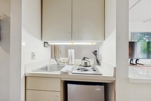 A compact kitchen with a sink, stove, and a dishwasher.