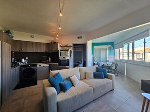A modern apartment with a kitchen, dining area, and living room. - Lovely 2-room apartment in a residence with a swimming pool, Plage Richelieu, Cap d'Agde (LE CAP D AGDE)