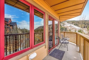 Ein Balkon mit Blick auf eine verschneite Landschaft und ein Gebäude im Hintergrund.