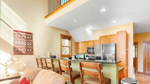 A kitchen with wooden cabinets, a refrigerator, and a microwave. - Centrally located with balcony, fireplace, heated garage parking & ski locker (Keystone)
