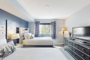 A bedroom with a bed, a dresser, a TV, and a window with curtains. - Mountain resort condo with off-site pool, gym, ski gondola, game room & firepit (Steamboat Springs)