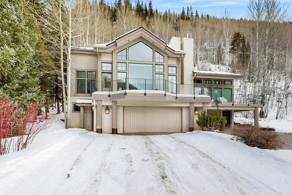 A large, modern house with a prominent front entrance, large windows, and a garage.