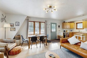 Ein gemütliches Wohnzimmer mit einer Couch, einem Couchtisch und einem Essbereich mit Stühlen und einem Tisch.