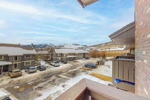Ein Wohngebiet mit mehreren Häusern, einem Parkplatz und Blick auf ferne Berge.