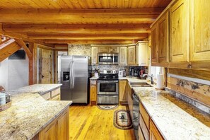 A kitchen with wooden cabinets, granite countertops, stainless steel appliances, and a wooden ceiling. - Ridgetop mountain-view home on 5 acres with Gas Grill, AC & fireplace (Pagosa Springs)