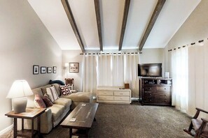 A living room with a sofa, a coffee table, a TV, and a cabinet.