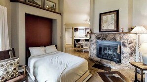 A hotel room with a bed, a fireplace, a desk, and a chair. - Dog-friendly studio with mountain views - near lakes, golf, ski area (Pagosa Springs)