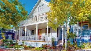 A two-story house with a porch, a red door, and a small window on the upper floor. - Beautiful Telluride house close to gondolas with private hot tub & fireplace (Telluride)