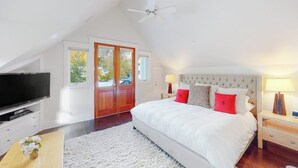 A bedroom with a large bed, a television, a ceiling fan, and a view of the outdoors. - Beautiful Telluride house close to gondolas with private hot tub & fireplace (Telluride)