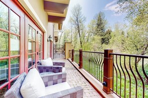 A balcony with outdoor seating and a view of trees. - Luxury mountain stay with resort amenities, work area, and shuttle to slopes (Avon)