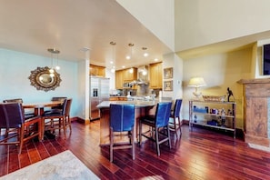 A spacious kitchen with wooden cabinets, a central island, and pendant lighting. - Luxury mountain stay with resort amenities, work area, and shuttle to slopes (Avon)
