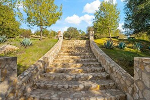 A stone staircase leading up a hill, surrounded by greenery and trees. - Rancho Agave Azul Family Retreat Near Wine Country (Murrieta)