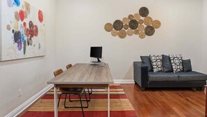 Een moderne woonkamer met een eettafel, bank en abstracte kunstwerken aan de wanden.
