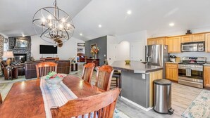 Een moderne keuken met houten kasten, roestvrijstalen apparatuur en een centraal kookeiland.