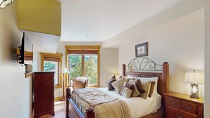 A bedroom with a bed, bedside table, lamp, and a window with blinds. - EagleRidge Lodge 206 Walk-to-gondola condo w/ fireplace, laundry & shared hot tubs/pool/gym/shuttle (Steamboat Springs)