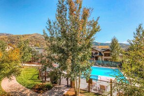 A hotel with a swimming pool, surrounded by trees and a mountain view. - EagleRidge Lodge 206 Walk-to-gondola condo w/ fireplace, laundry & shared hot tubs/pool/gym/shuttle (Steamboat Springs)