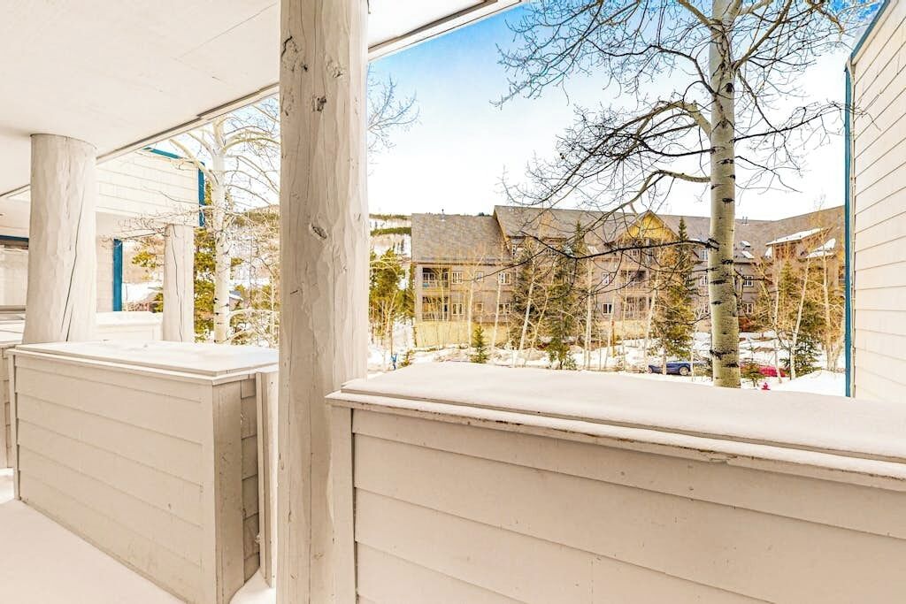 Et overdækket udendørs område med udsigt til boliger og nøgne træer.