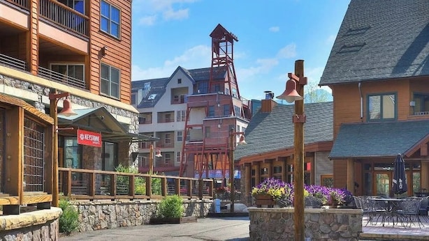 Un hotel con facciata in pietra, balconi in legno e un campanile.