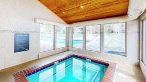 A spa area with a wooden ceiling, a pool, and windows with a view of the outside. - Conveniently located condo with full kitchen, fast wifi, shared pool & hot tub (Keystone)