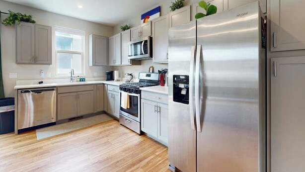 A modern kitchen with stainless steel appliances, a dishwasher, and a microwave.