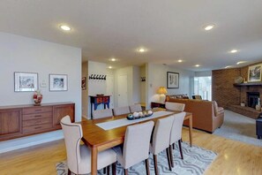 A dining area with a wooden table and chairs, a sofa, and a fireplace. - Modern Mountain View Hideaway w/ Spacious Deck & Free WiFi - Close to Skiing (Silverthorne)