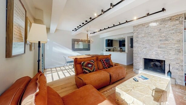 Un salon moderne avec un canapé, une table basse et une cheminée.