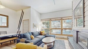 A modern living room with a sectional sofa, a round coffee table, and a fireplace. - Kutuk 108 Ski, stay, & play - Steamboat Springs getaway only steps away from the mountain (Steamboat Springs)