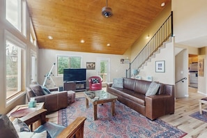 A spacious living room with a wooden ceiling, leather sofas, a glass coffee table, and a staircase leading to another level. - Secluded Mountain Cabin w/ Hot Tub, Fireplace & Stargazing Deck near Breck (Alma)