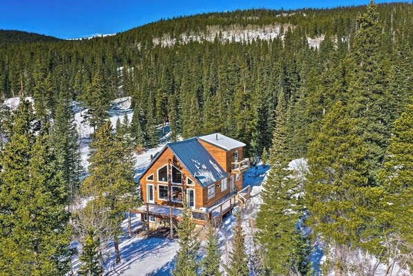 A cabin with a large deck, surrounded by dense forest and snow. - Secluded Mountain Cabin w/ Hot Tub, Fireplace & Stargazing Deck near Breck (Alma)