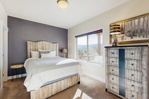 A bedroom with a bed, a dresser, a window with a view, and a ceiling light. - Modern townhome w/ mountain views, 2 outdoor spaces, & a gas grill (Fraser)